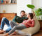 Shot of a smiling young couple talking together while relaxing on a beanbag sofa at home